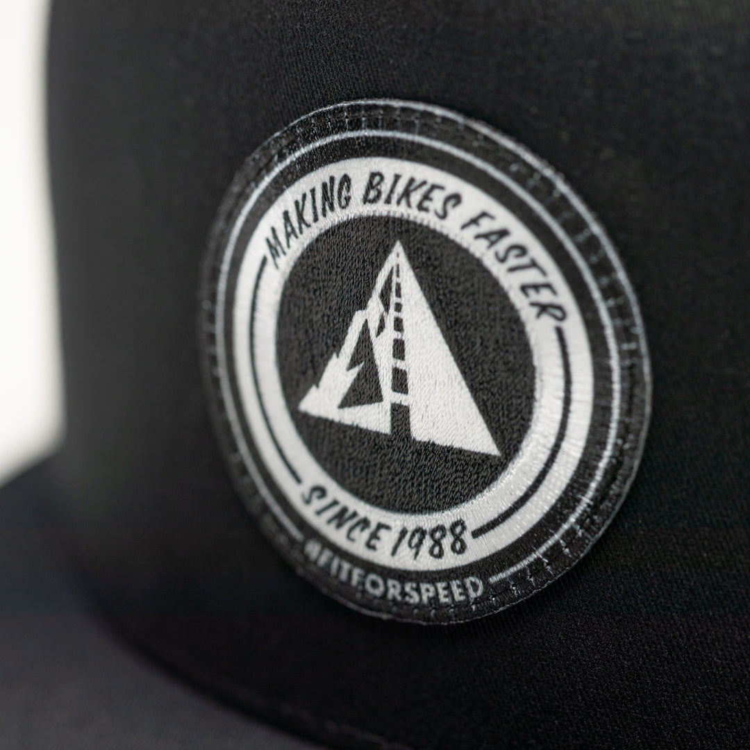 Profile Design Black cap with a circular logo featuring text and a triangle design.